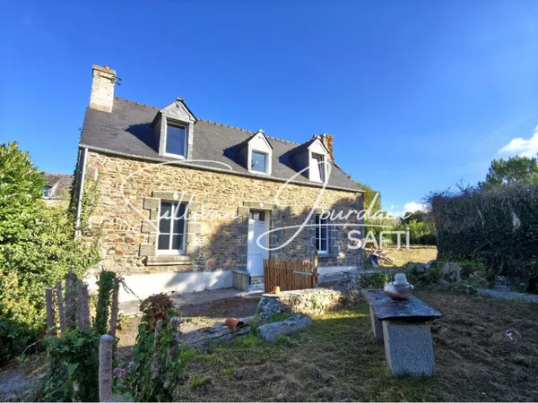 Maison en pierre à rénover sur un grand terrain.