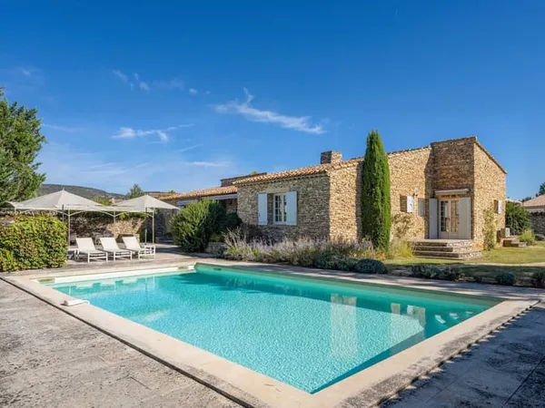 Maison en pierre avec piscine et joli jardin paysager à Gordes.