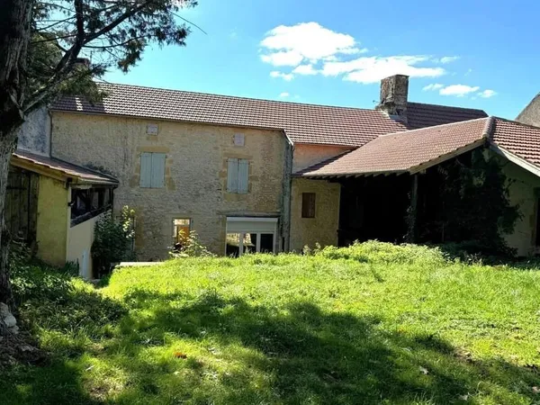 Charmante maison de village spacieuse en pierre avec superbe jardin et beau potentiel.