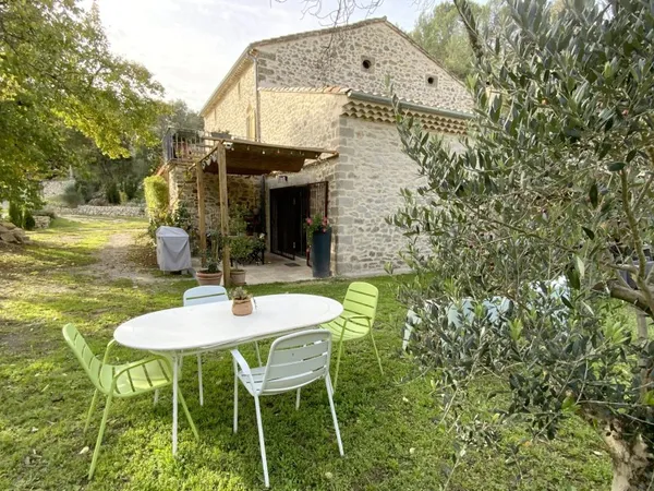 Maison en pierre rénovée avec jardin arboré.