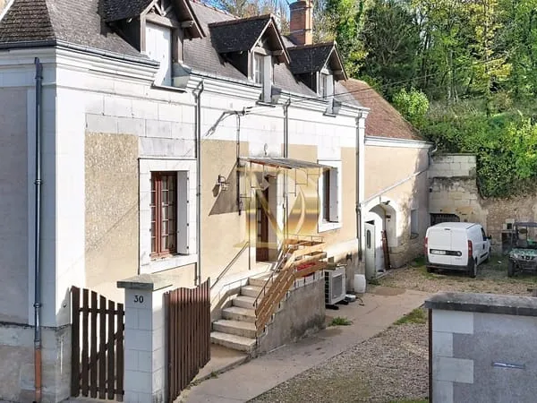 Une maison, des dépendances, caves et boisé
