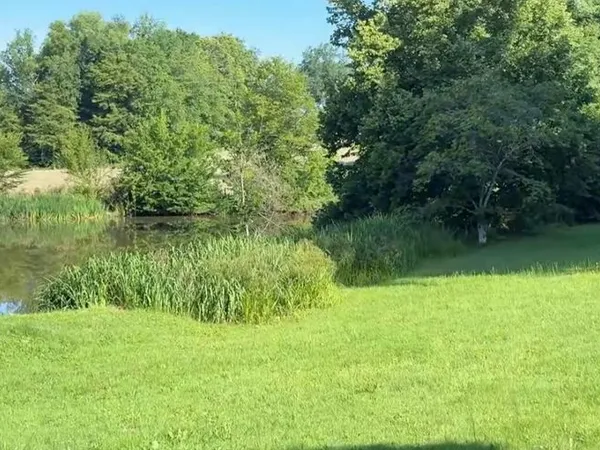 Etang sur terrain arboré avec bâtiment