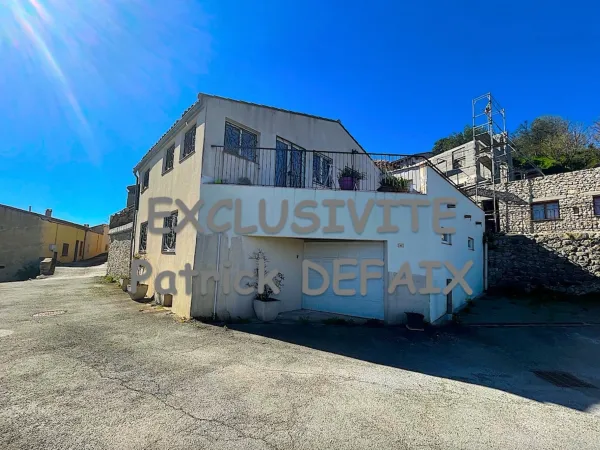 Maison de village avec garage et terrasse.