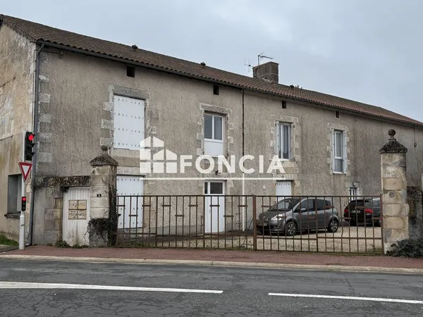 Corps de ferme divisé en 4 logements dont 1 actuellement loué + grand garage + grande grange