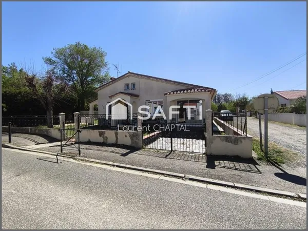 Maison de plain pied avec garage et jardin.