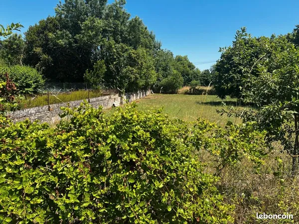Terrain constructible avec bâtiment ancien