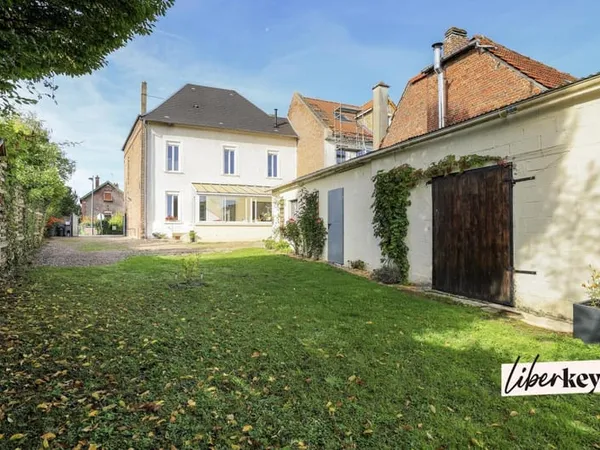 Maison 4 chambres, 180 m² avec local commercial loué, cour, jardin et potentiel d'aménagement