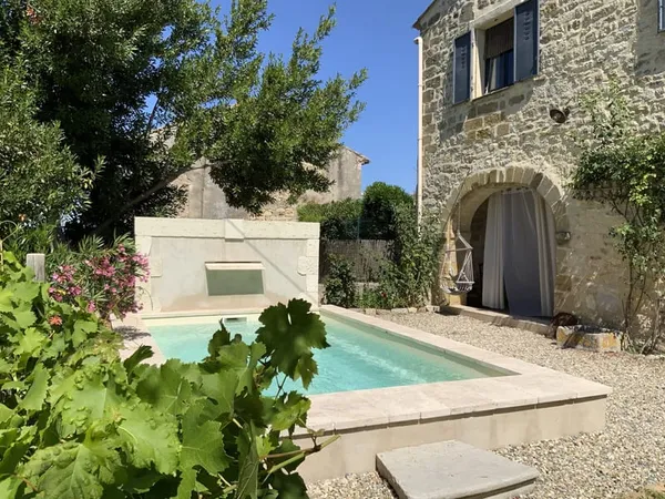 Maison de village en pierre avec terrain et piscine.
