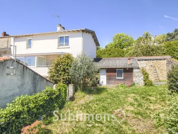 Maison de bourg avec un jardin et un double garage.