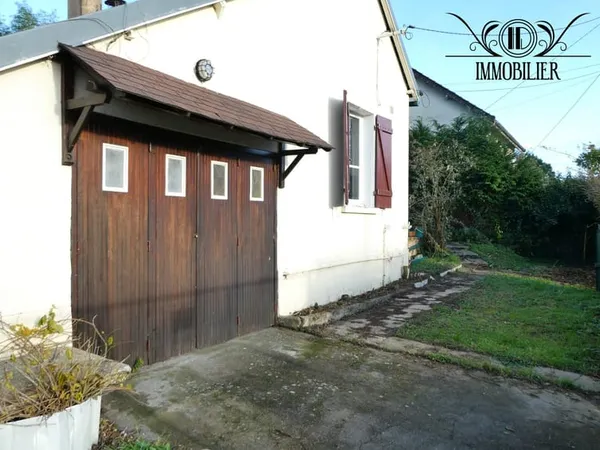 Maison avec véranda et garage.