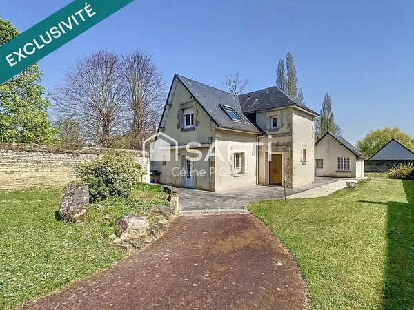 Maison familiale avec grands espaces de vie, dépendances et garage.