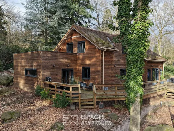 Maison familiale en bois au coeur d'un environnement boisé.