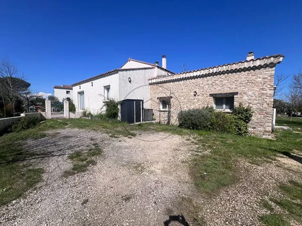 Maison de plain pied sur terrain arboré.