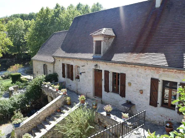 Dans un très typique village du Lot propriété en pierre avec gîte. Vue dominante 