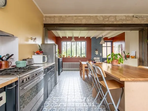 Maison de caractère avec grange et jardin arboré en coeur de village.