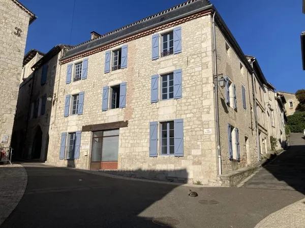 Maison en pierre à rénover avec local professionnel restauré en activité.