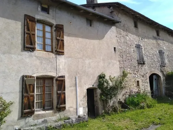 Maison à rénover, grange et terrain menant à un ruisseau.