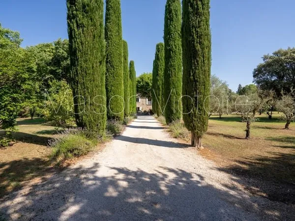 Mas en pierre de caractère entouré de jardins paysagers.