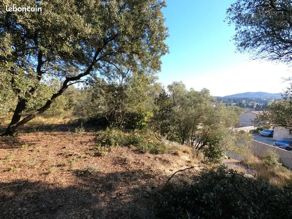 Terrain constructible de 854 m² viabilisé, en position dominante , avec vue dégagée , proche commodi