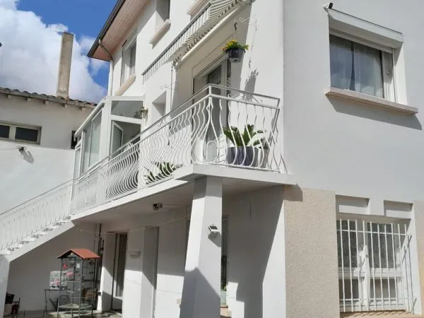 Maison de ville avec garage et jardin.