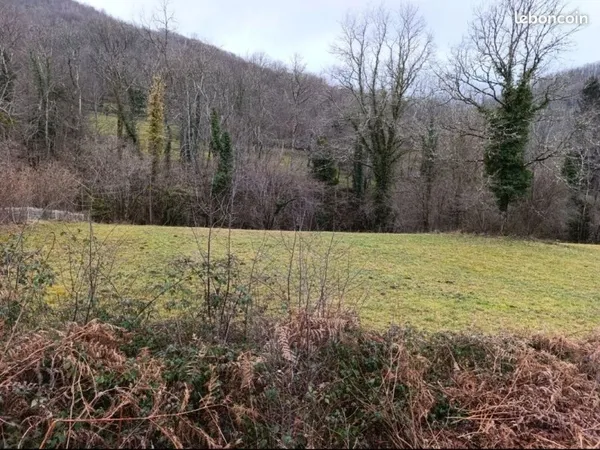 Terrain agricole de 1200 M2 Plat et nu exposé plein sud avec une rivière longeant. En bord de route.