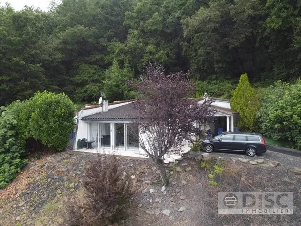 Maison de plain-pied avec vue et parcelle en bordure de rivière.