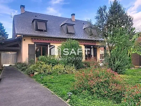 Maison de ville traditionnelle avec 4 chambres et un grand garage.