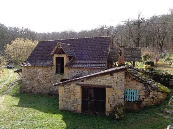 Ancien petit corps de ferme en pierre dans un cadre de verdure avec vue dégagée, éloigné des grandes