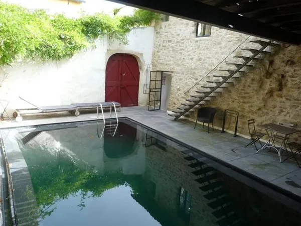 Ensemble de trois maisons de village en pierre autour d'une cour avec piscine