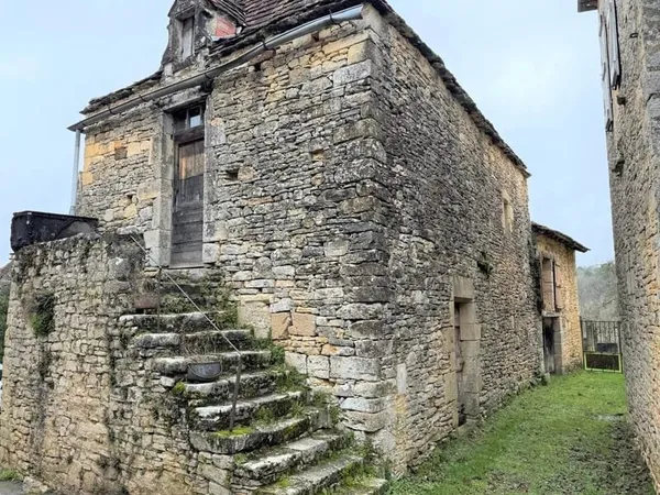 Maison ancienne en pierre avec jardinet.