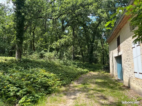 Belle maison gersoise en pierre dans un bois