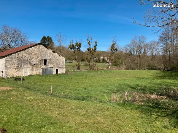 Terrain bordé par un ruisseau avec ancienne ferme / grange