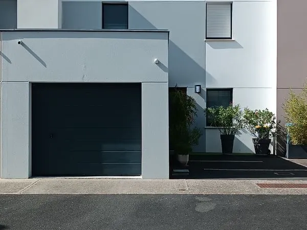 Maison faible consommation d'énergie avec garage et jardin arboré